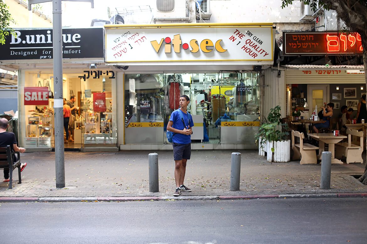 נער עומד מול חנות לניקוי יבש